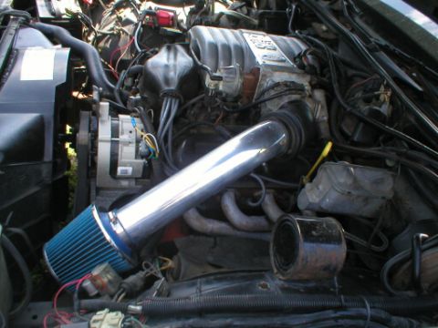 1987 Ford Crown Victoria LTD - Close-up of an engine bay an aftermarket air intake system and various engine components.