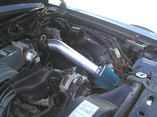 Engine bay of a 1987 Ford Crown Victoria LTD with aftermarket air intake and blue air filter
