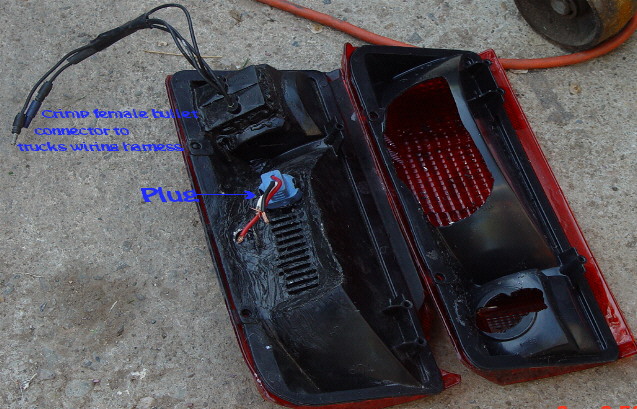 Disassembled red taillight assembly with wiring, annotated to show plug and crimp connector locations