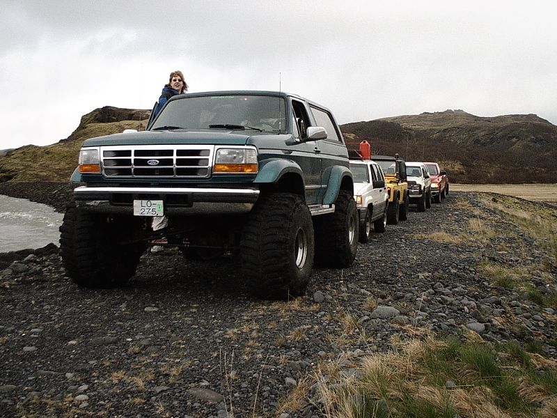 Green lifted two-door Ford Bronco on big mud tires with Icelandic plate LO-275, on a gravel road.