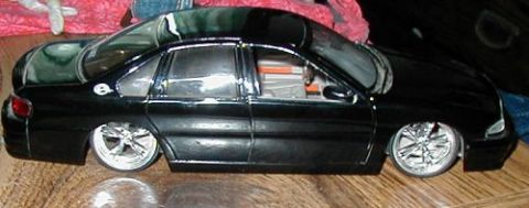 1997 Ford Taurus - A black model sedan with custom rims sits on a wooden surface.