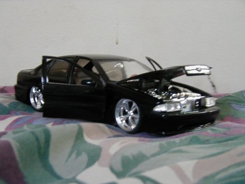 Black toy car with doors and hood open, showing engine detail