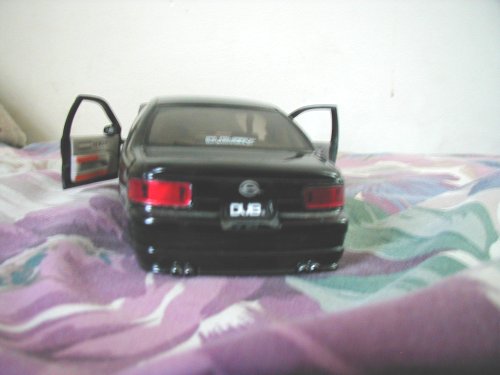 Black toy car with open doors and DUB badging on the rear