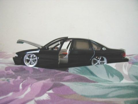 1997 Ford Taurus - Toy car with open hood and doors on a patterned blanket.