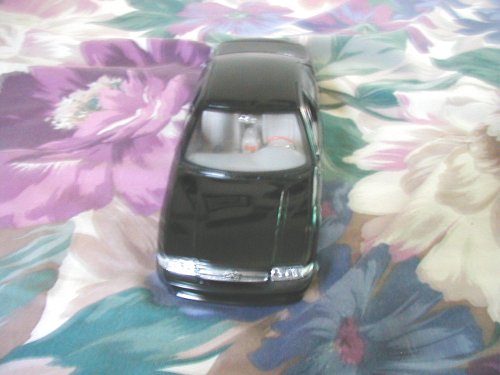 Black toy car on floral fabric, front view