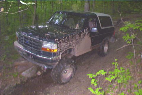 1995 Ford Bronco - This 1995 Ford Bronco is covered in mud after an off-road excursion in a wooded area.