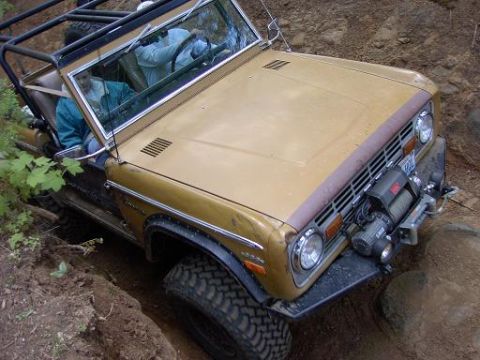 1980 Ford Bronco - This off-road vehicle, likely a 1978 Ford Bronco, navigates a challenging dirt path with a winch mounted on its front.