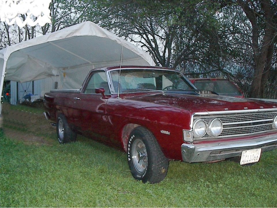 Maroon 1968 Ford Ranchero pickup, 3/4 front view, under a white tent on grass.