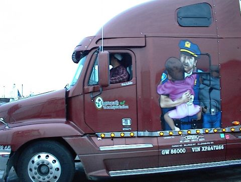 1997 Ford Expedition - A semi-truck features a mural depicting a police officer embracing a child, with company and vehicle identification visible.