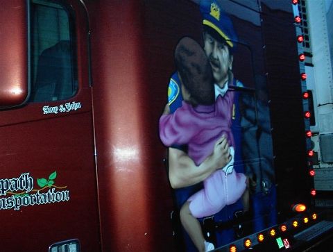 1997 Ford Expedition - A truck side displays a mural of a police officer embracing a child, with company and personal names visible.
