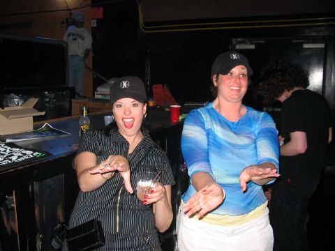 1989 Ford Bronco - Two women are having fun at a bar, with one holding a drink and the other smiling.