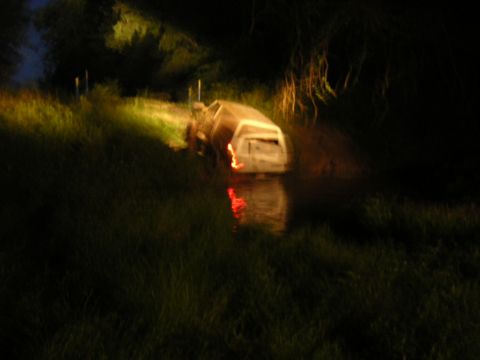 1984 Chevrolet Blazer - A white SUV is stuck in water at night, with its rear lights reflecting in the water.
