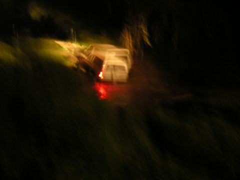1984 Chevrolet Blazer - Two vehicles are visible at night, with one white van showing its red taillights.