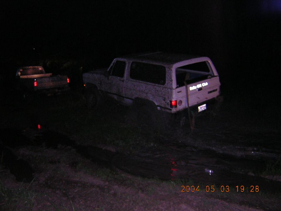 1984 Chevrolet Blazer stuck in mud at night, another truck visible behind it