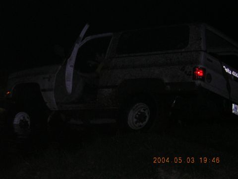 1984 Chevrolet Blazer - A muddy SUV sits with its doors open in the dark, possibly stuck off-road.