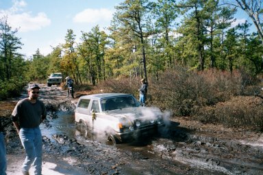 1979 Ford Bronco II - Off-roading adventure with multiple vehicles navigating a challenging muddy terrain.