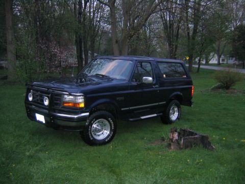 1994 Ford Bronco - This 1994 Ford Bronco is parked on a grassy lawn in front of trees.
