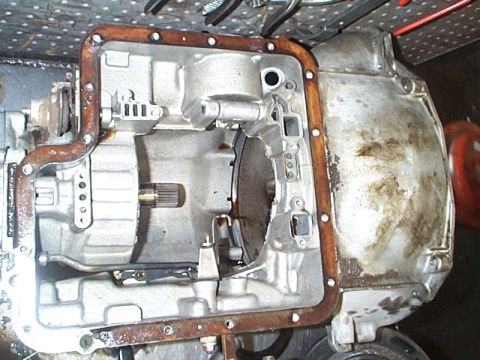 1981 Ford Bronco - Automatic transmission lying on a bench with the pan removed, exposing the aluminum valve body, filter mounting boss, splined input shaft s…