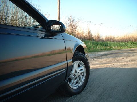 1996 Ford Thunderbird - Side view of a dark blue car, focusing on the wheel and body panel.