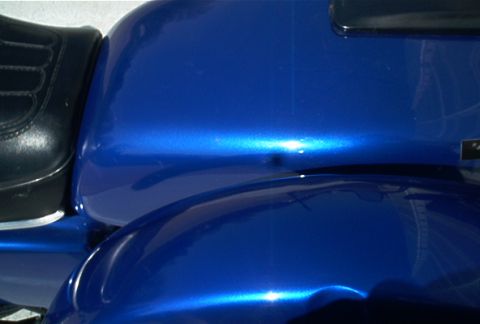 1985 Ford Crown Victoria LTD - Close-up view of a blue metallic motorcycle's fender and seat.