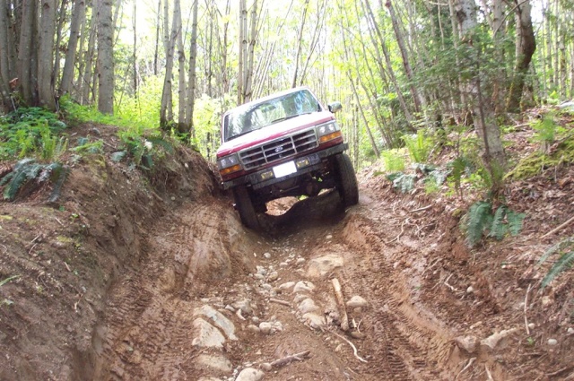 1992 Ford F-150 navigating a steep, muddy off-road trail