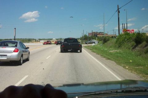 1992 Ford Bronco - Driving on the highway behind a black pickup truck, with other vehicles visible.