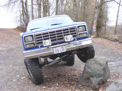 1980 Ford Bronco - This blue pickup truck, likely from the 1980s based on its grille, navigates an obstacle on a rocky trail.