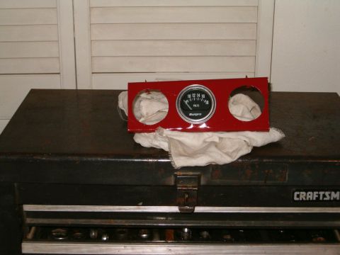 1979 Ford Bronco - A red gauge cluster with a voltmeter is displayed on a toolbox, with visible text 'SUPERMOTORS'.