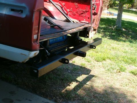 1979 Ford Bronco - The rear of a pickup truck shows a custom bumper with a trailer hitch and tow points.