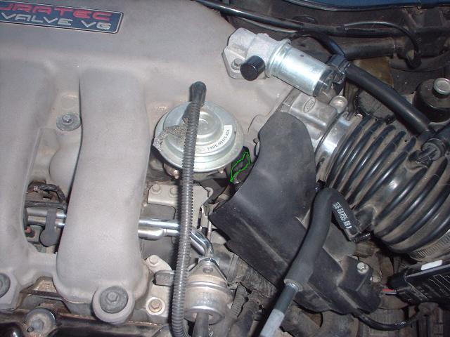 Close-up of engine components including intake manifold, throttle body, and EGR valve