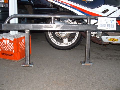 1991 Ford Bronco - A custom metal slider bar is shown, supported by an orange milk crate, with a motorcycle wheel visible in the background.