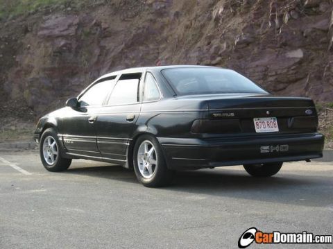 1998 Ford Taurus - Rear view of a black sedan with 'TAURUS' and 'SHO' badging, parked outdoors.