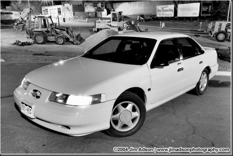 1998 Ford Taurus - White 1998 Ford Taurus parked at a construction site at night.