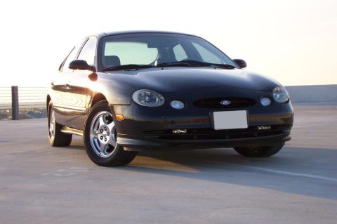 1998 Ford Taurus - Front 3/4 view of a black 1998 Ford Taurus parked outdoors during the day.