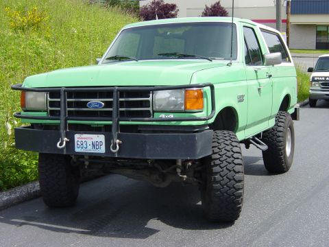 1990 Ford Bronco - This 1990 Ford Bronco features a prominent brush guard and an elevated suspension system, giving it a stance.