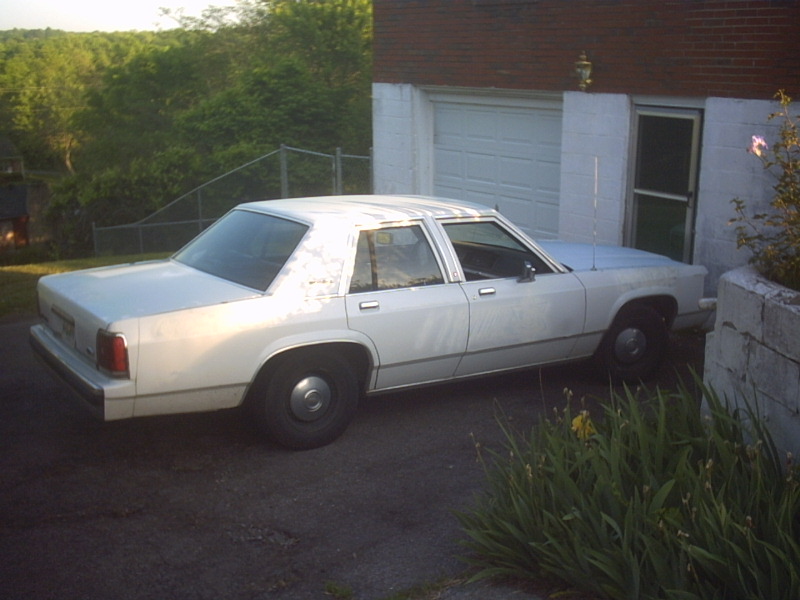 White 1991 Ford Crown Victoria sedan parked outside a garage