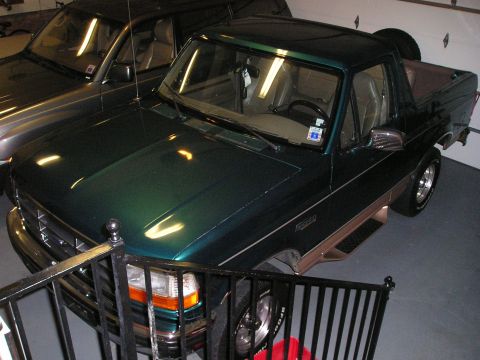 1996 Ford Bronco - A green 1996 Ford Bronco is parked in a garage next to another vehicle.