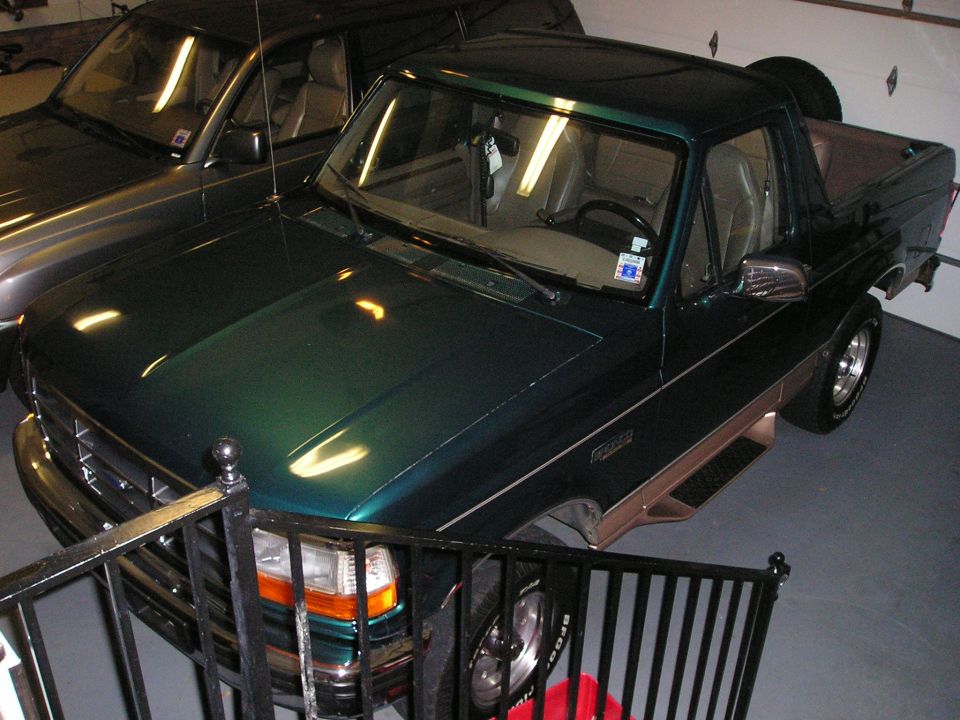 Green and tan Ford Bronco indoors with the rear top removed, viewed from above