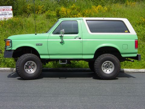 1990 Ford Bronco - This lifted 1990 Ford Bronco is seen from the side, a two-tone green and white paint scheme.