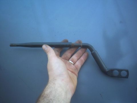 1991 Ford Crown Victoria - A hand holds a metal automotive part against a blue background.