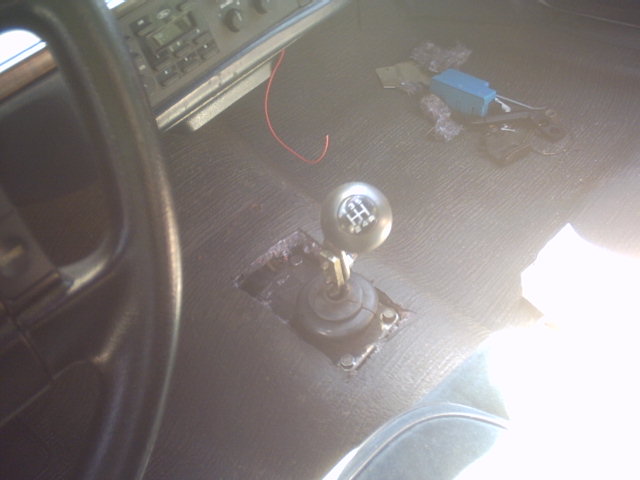 Car interior showing a floor shifter, dashboard, and some wires on the floor