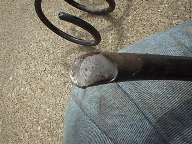 Close-up of a broken metal spring and its end