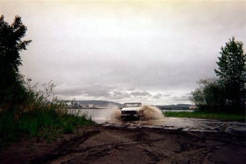 1978 Ford Bronco - This 1978 Ford Bronco is navigating through water and mud, creating a significant splash.