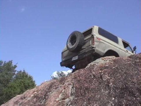 1978 Ford Bronco - This 1978 Ford Bronco is navigating a challenging rocky terrain under a clear blue sky.