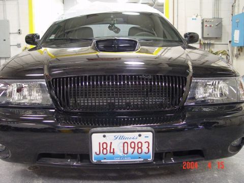 1998 Ford Crown Victoria - Front view of a black sedan with a custom grille and hood scoop. Date stamp shows 2006.