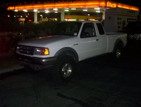 2000 Ford F-450 - A white Ford Ranger pickup truck is parked at a gas station at night.