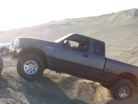 2000 Ford F-450 - Ford Ranger pickup truck navigates a sandy hill in an off-road environment.