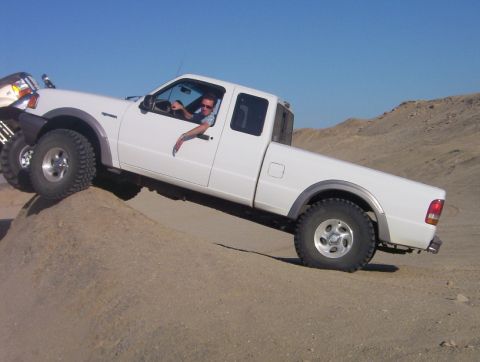2000 Ford F-450 - White Ford Ranger pickup truck navigates a challenging off-road terrain with a second vehicle nearby.