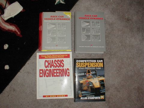 1983 Ford Bronco - Collection of four automotive engineering books laid out on a carpeted floor.
