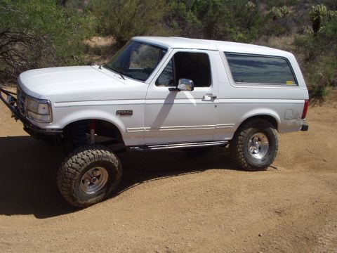 1993 Ford Bronco - Modified 1993 Ford Bronco on a dirt path, showing off its off-road capabilities.